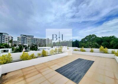 Spacious rooftop with a view of surrounding buildings and greenery