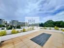 Spacious rooftop with a view of surrounding buildings and greenery