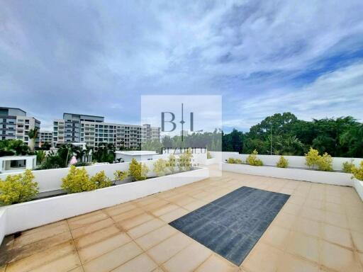 Spacious rooftop with a view of surrounding buildings and greenery