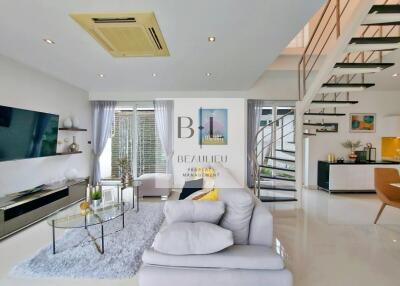 Modern living room with large windows and a staircase