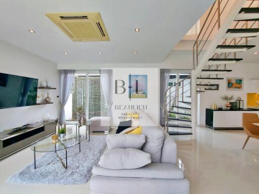 Modern living room with large windows and a staircase