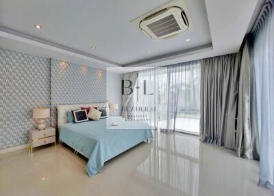 Modern bedroom with blue and white decor and large windows