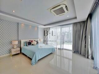 Modern bedroom with blue and white decor and large windows