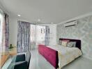 Modern bedroom with floral-patterned curtains and wallpaper, featuring a maroon velvet bed, glass desk, and air conditioning unit