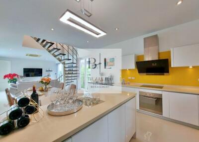 Modern kitchen with white cabinets, island counter, and stainless steel appliances