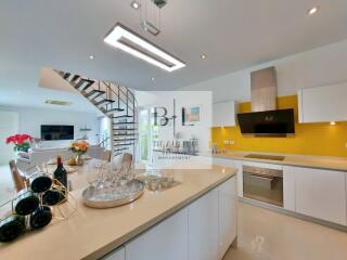 Modern kitchen with white cabinets, island counter, and stainless steel appliances