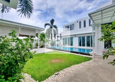 Modern white building with pool and green lawn