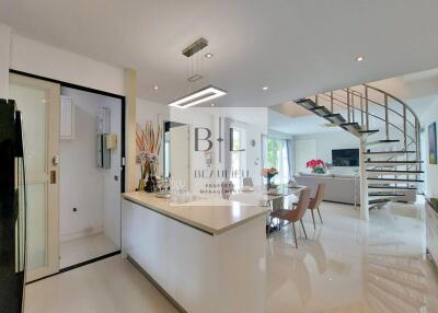 Modern open-plan kitchen and living room with spiral staircase