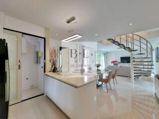 Modern open-plan kitchen and living room with spiral staircase