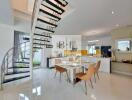 Modern living area with dining table, kitchen, and spiral staircase