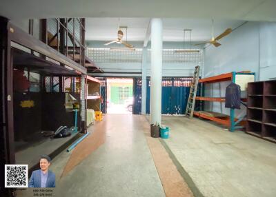 Spacious open area in a building with shelves and overhead fans