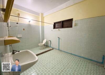 Spacious bathroom with sink, toilet, and tiled walls