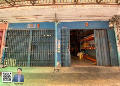 Front view of a blue commercial building with metal gates