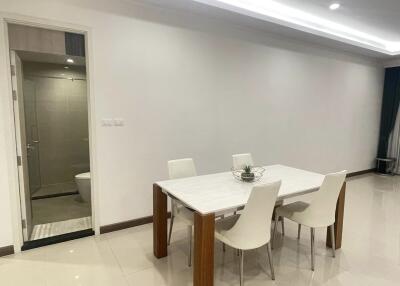 Modern dining area with a table and chairs, adjacent to a clean bathroom