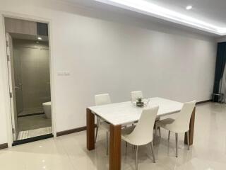 Modern dining area with a table and chairs, adjacent to a clean bathroom