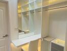 Well-lit modern walk-in closet with seated vanity area