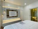 Modern bedroom with bed, lit mirror, and wardrobes