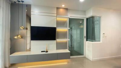 Modern living room with built-in TV unit and sliding glass door