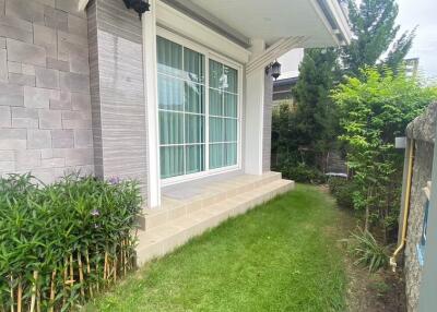 Exterior view of a house with a porch and a small grassy area