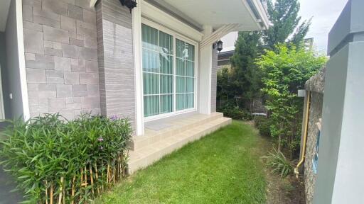 Exterior view of a house with a porch and a small grassy area