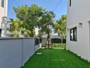 Backyard area with lawn and trees between two buildings