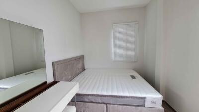 Minimalist bedroom with bed, mirror, and window