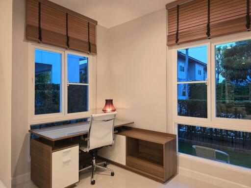 Modern home office with a desk, chair, and large windows