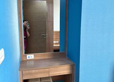 Bedroom with vanity desk, mirror, and ottoman