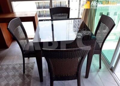 Dining area with glass-top table and four wicker chairs