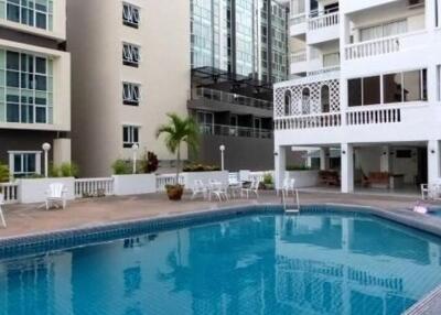 Outdoor swimming pool area with surrounding seating at a residential building