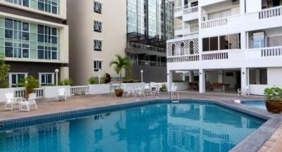 Outdoor swimming pool area with surrounding seating at a residential building