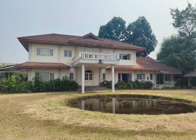 Exterior view of a two-story house with a pond