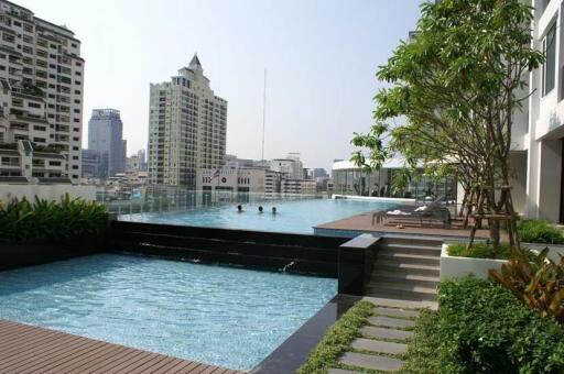 Outdoor swimming pool view with cityscape in the background