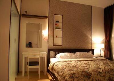 Bedroom with double bed, desk, and wall-mounted shelves