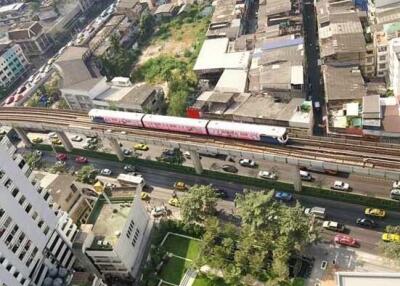 Aerial view of an urban area with buildings and a public transportation train passing through.