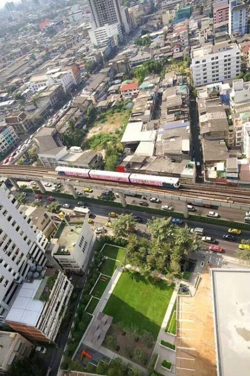 Aerial view of an urban area with buildings and a public transportation train passing through.