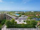 Aerial view of modern residential complex with abundant greenery and ocean in the background