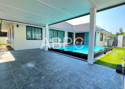 Covered patio area with view of swimming pool and house