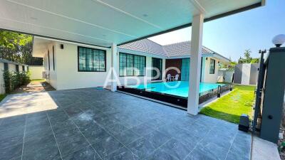 Covered patio area with view of swimming pool and house