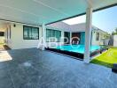 Covered patio area with view of swimming pool and house