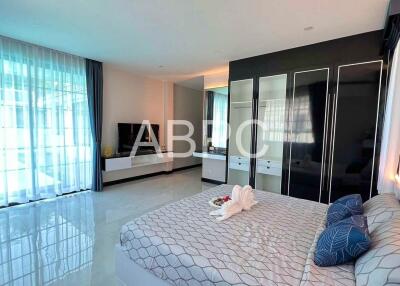 Modern bedroom with large bed, built-in wardrobe, and TV unit