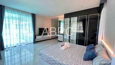 Modern bedroom with large bed, built-in wardrobe, and TV unit