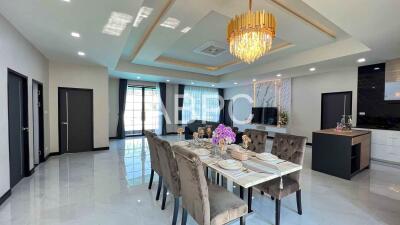 Modern dining room and living area with chandelier