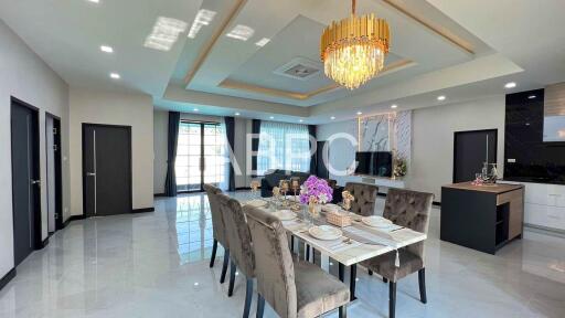 Modern dining room and living area with chandelier