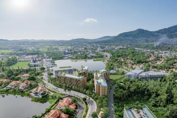 Aerial view of modern residential complex surrounded by greenery and water bodies