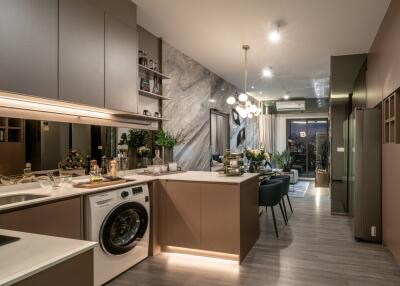 Modern kitchen with island, washing machine, stove, and dining area