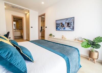 Modern bedroom with blue bedding and wall-mounted TV