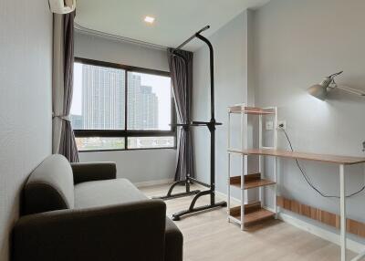 Bedroom with sofa, desk, and standing exercise equipment