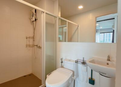 Modern bathroom with glass-enclosed shower, toilet, and sink