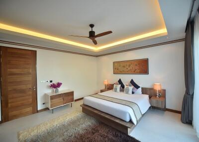 Modern bedroom with large bed, ceiling fan, and ambient lighting